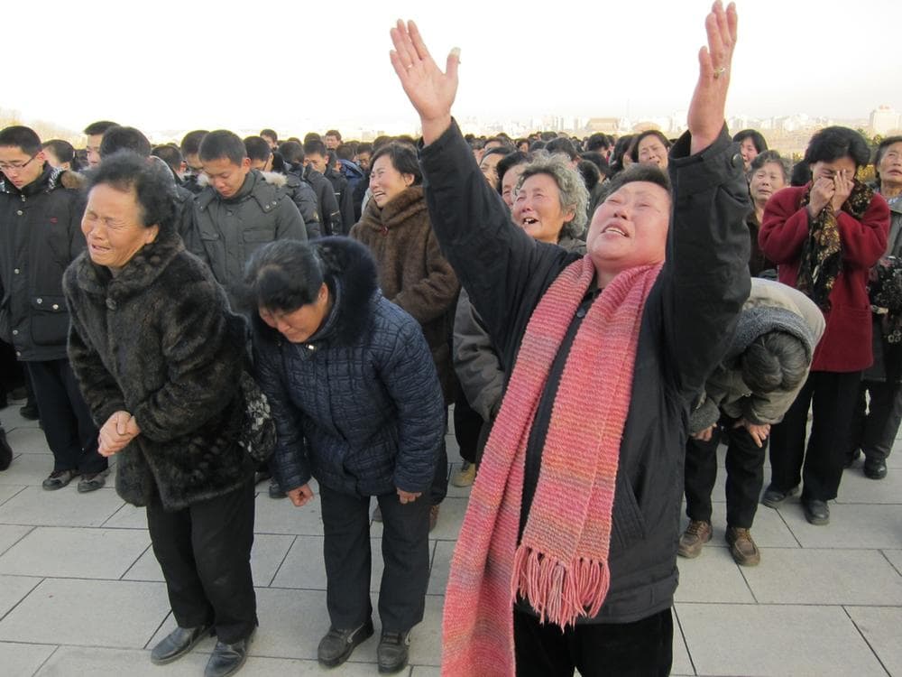 North Koreans cry and scream in a display of mourning for their leader Kim Jong Il at the foot of a giant statue of his father Kim Il Sung in Pyongyang, North Korea, after Kim Jong Il&#039;s death was announced Monday. (AP/APTN)