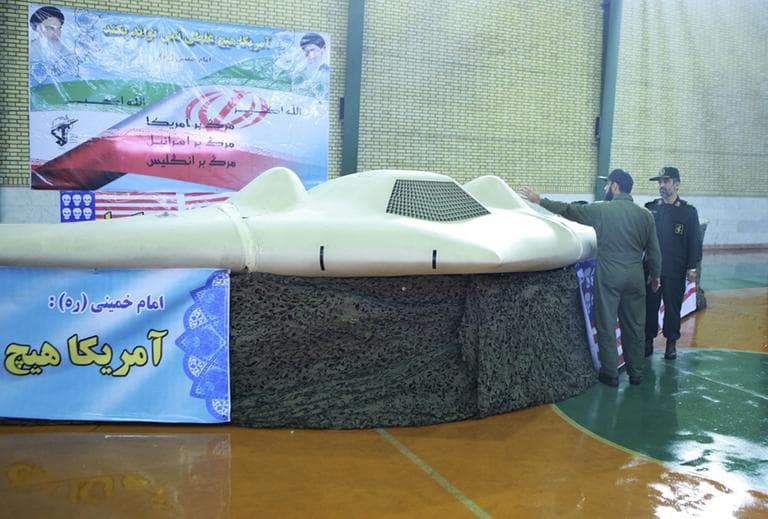 This photo released on Thursday, Dec. 8, 2011, by the Iranian Revolutionary Guards, claims to show US RQ-170 Sentinel drone which Tehran says its forces downed earlier this week, as the chief of the aerospace division of Iran's Revolutionary Guards, Gen. Amir Ali Hajizadeh, right, listens to an unidentified colonel, in an undisclosed location, Iran. (AP)