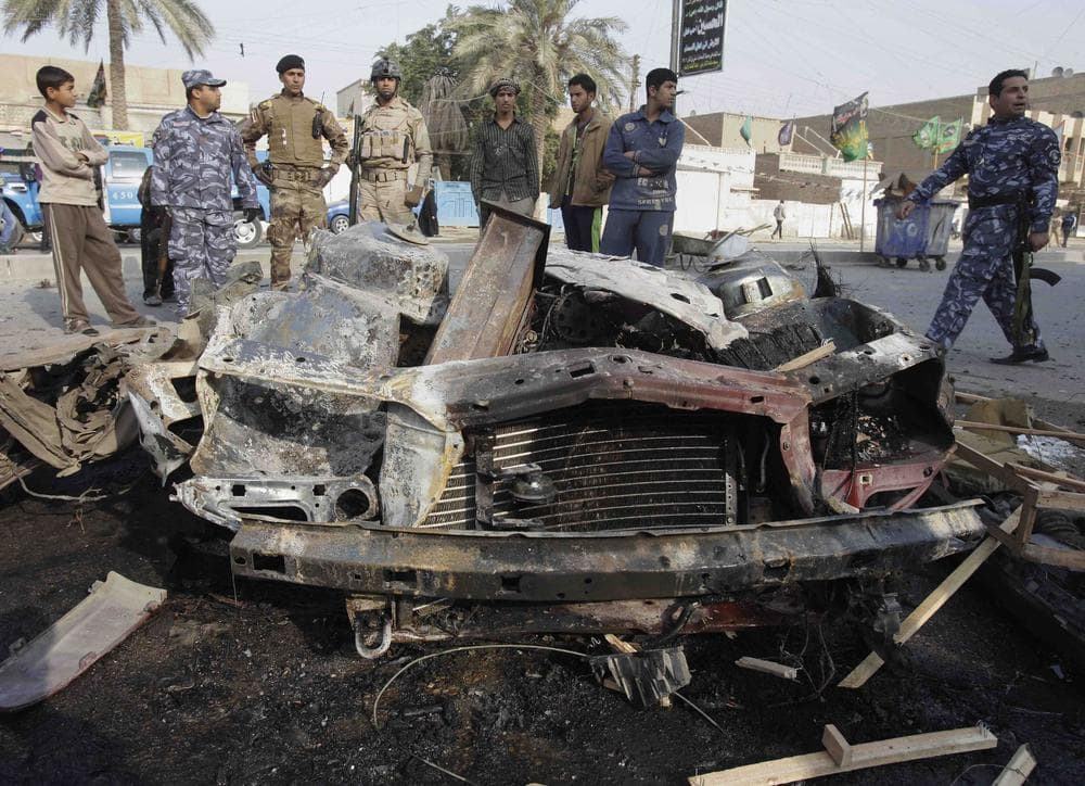 Iraqi security forces and people gather the scene of a car bomb attack in Baghdad, Iraq, Thursday. (AP)