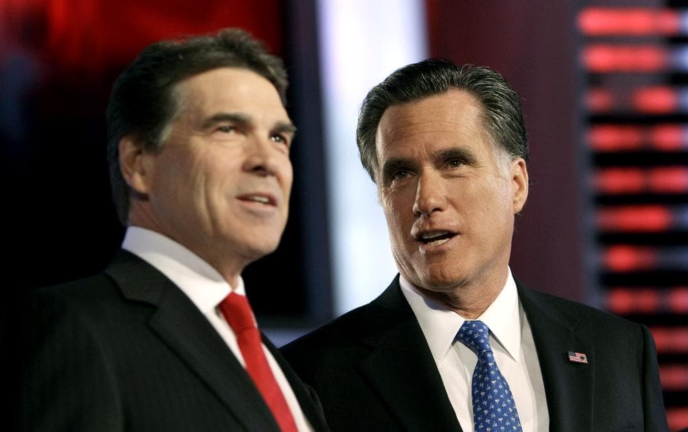 Republican presidential candidates, Texas Gov. Rick Perry, left and, former Massachusetts Gov. Mitt Romney, right, talk prior to the Republican debate in Des Moines, Iowa. (AP)