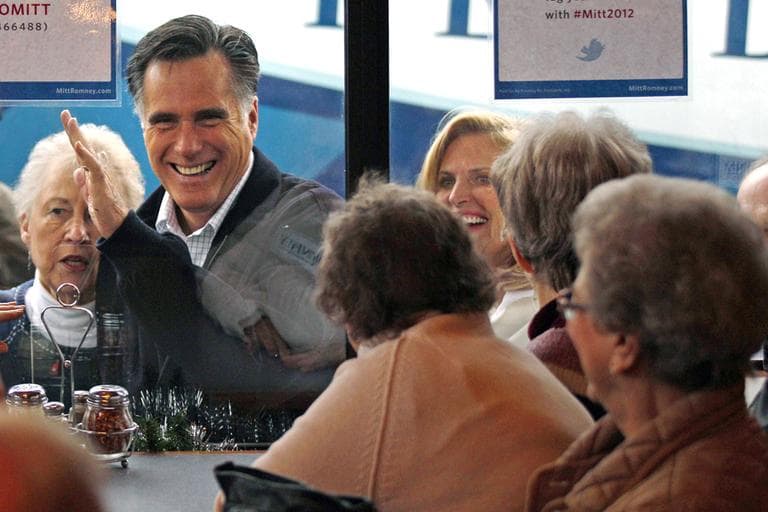 Republican presidential candidate former Mass. Gov. Mitt Romney waves to patrons through a window while campaigning at Village Pizza in Newport, N.H., Wednesday. (AP)
