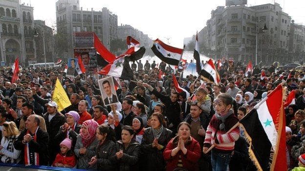 Syria's embattled President Bashar Assad still has supporters, particularly among his fellow Alawites, a minority who believe they will suffer if Assad is ousted. Here, Assad supporters rally Tuesday in the capital, Damascus. (SANA handout / EPA /Landov) 
