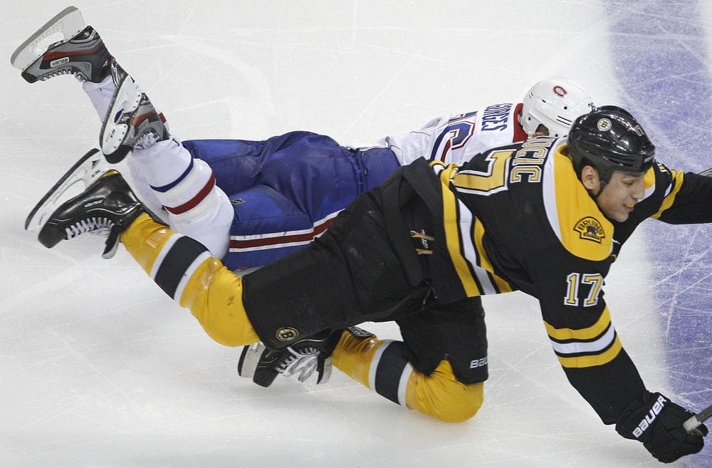 Bruins left wing Milan Lucic (17) and Canadiens defenseman Josh Gorges (26) collide in the third period.