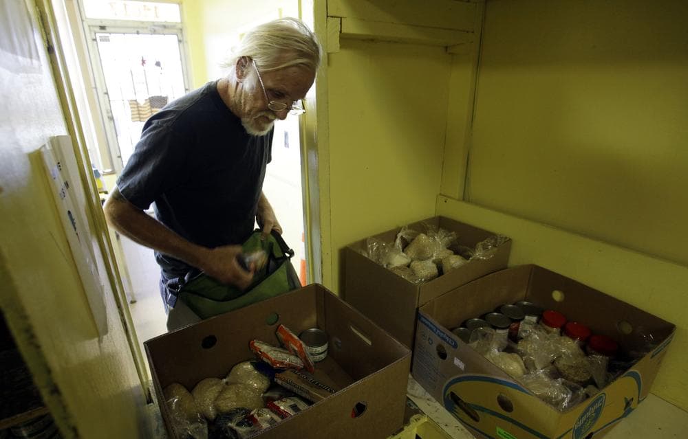 Larry Whitten, 59, packs donated food into a duffel bag to carry home, from a food pantry at the Pass It On Ministries in Miami. (AP)