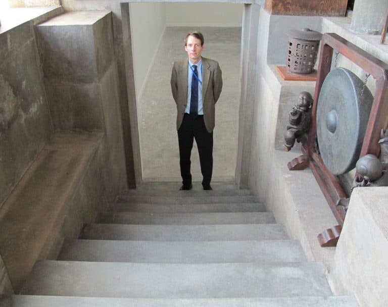 Museum curator Oliver Tostmann, in the steps leading to the hidden room beneath the Chinese loggia (Andrea Shea/WBUR)