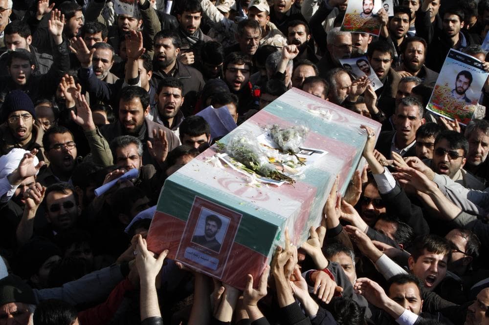 Iranians on Friday carry the flag draped coffin of Mostafa Ahmadi Roshan,a chemistry expert and a director of the Natanz uranium enrichment facility in central Iran, who was killed in a brazen daylight assassination Wednesday in Tehran.(AP)