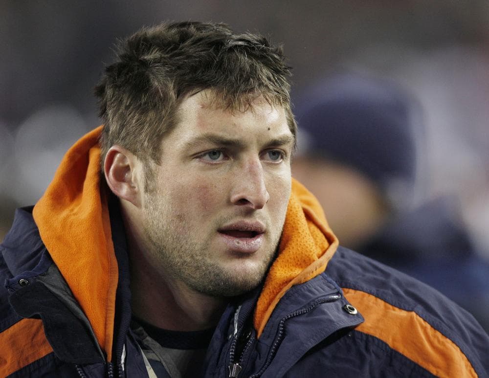 Tim Tebow watches from the sidelines during the first half Saturday. (AP)