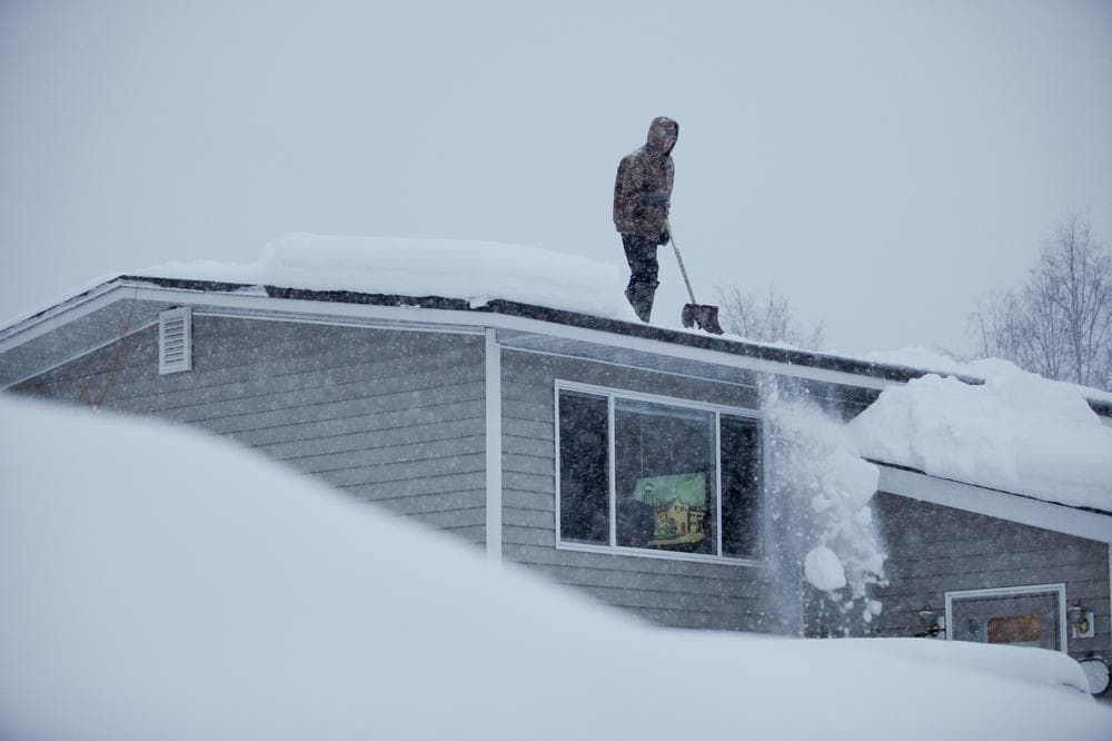 14-year-old Doug Hamrick shovels snow off of his family&#039;s roof in Anchorage. (AP)