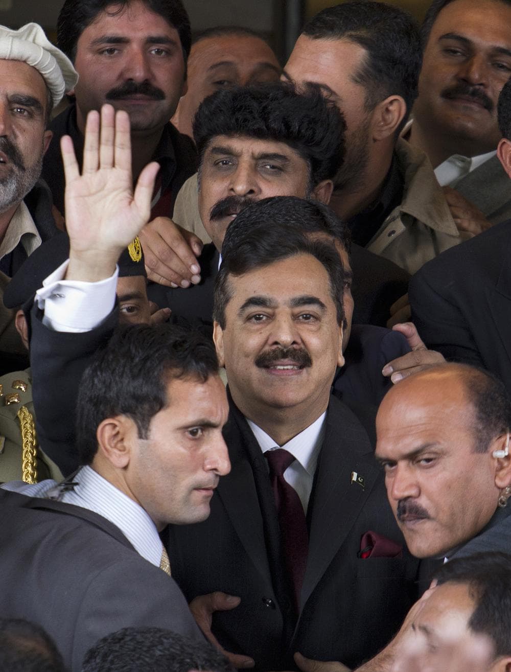 Pakistani Prime Minister Yousuf Raza Gilani waves as he leaves the Supreme Court in Islamabad, Pakistan on Thursday. (AP)