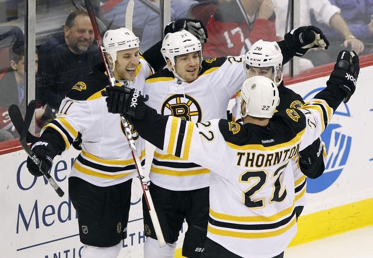Boston Bruins' Andrew Ference (21) celebrates with Gregory Campbell (11), Daniel Paille (20) and Shawn Thornton (22) after Ference scored in the third period in Newark, N.J., on Thursday. (AP)