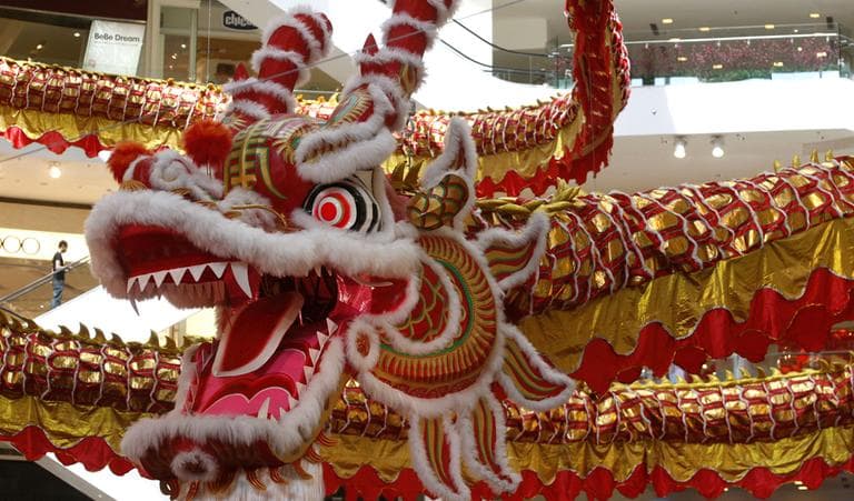 A man walks on an escalator next to a giant dragon decoration for the upcoming Chinese New Year of the Dragon at a shopping mall in Kuala Lumpur, Malaysia, Friday, Jan. 6, 2012. (AP)