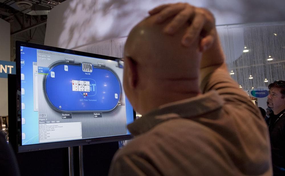 Casino industry representatives and exhibitors watch an online poker game during industry conference in Las Vegas. (AP)