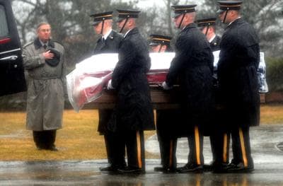 Under heavy downpours and grey skies, the casket containing the body of Army Spc. Keith Benson is removed from a hearse at the Massachusetts National Cemetery in Bourne, Massachusetts Friday during a graveside service. (David Curran/ SatelliteNewsService.com)