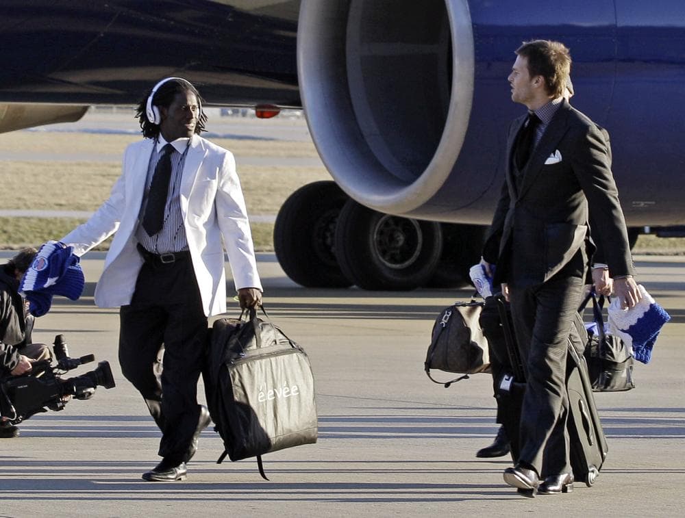 New England Patriots wide receiver Deion Branch, left, talks to Tom Brady as they arrive at the Indianapolis International Airport for Super Bowl XLVI Sunday, in Indianapolis. (AP)