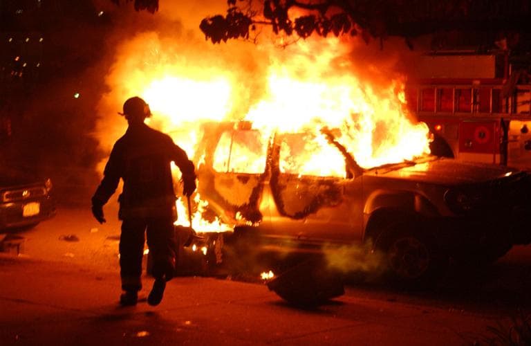 A fireman approaches a burning car outside of Fenway Park following a Boston Red Sox victory over the New York Yankees in October, 2004. (AP)