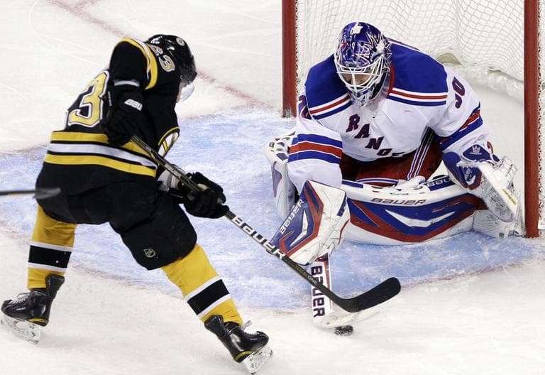 New York Rangers goalie Henrik Lundqvist, of Sweden, pushes the puck away from Boston Bruins left wing Brad Marchand in the third period of an NHL hockey game in Boston, Tuesday. (AP)