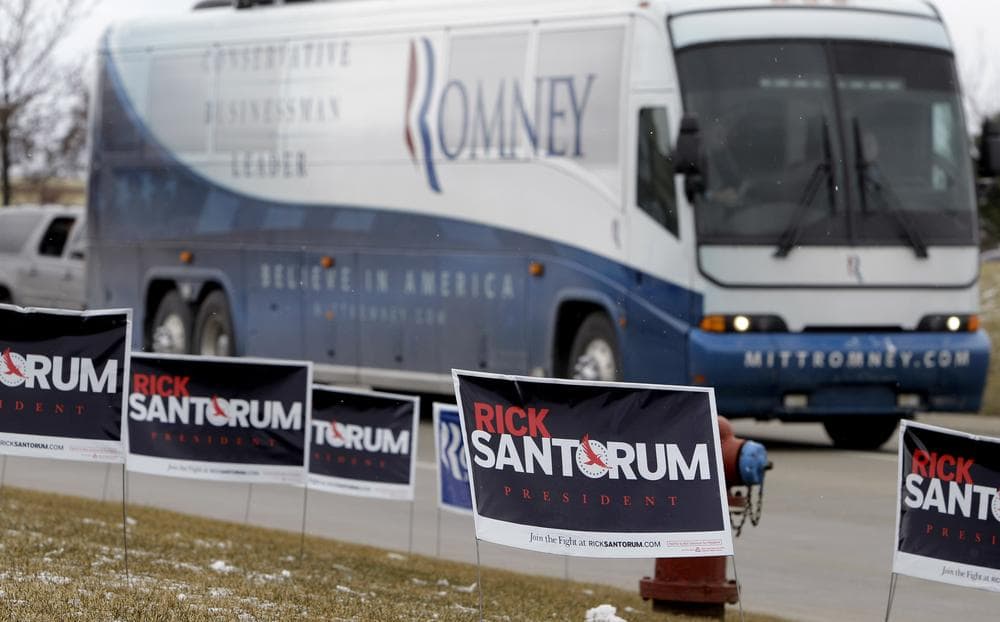The campaign bus carrying Republican presidential candidate and former Massachusetts Gov. Mitt Romney passes by campaign signs for rival GOP candidate, former Pennsylvania Sen. Rick Santorum in Mich. (AP)