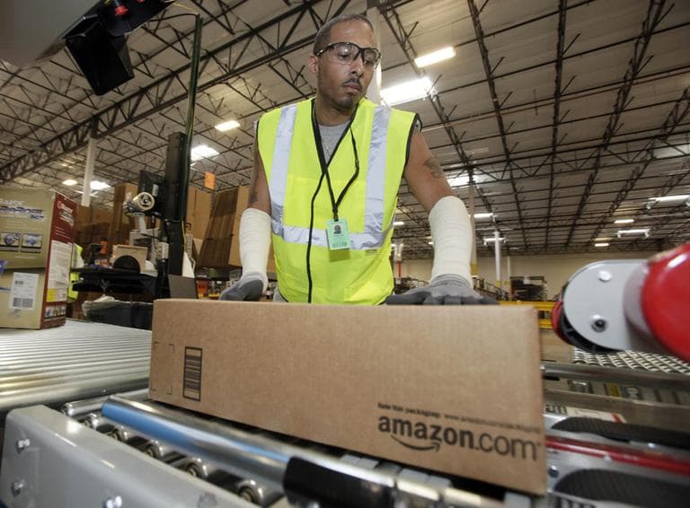 In this Nov. 16, 2009 photo, Reginald Armstead, Jr., of Phoenix, sends a package on its way after packing it at the 800,000 sq. ft. Amazon.com warehouse in Goodyear, Ariz. (AP)
