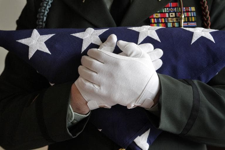 A National Guard captain holds a folded American flag. (AP)