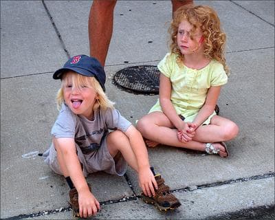 two children sitting on the sidewalk