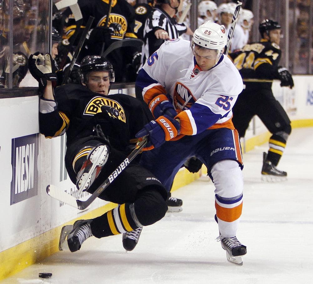 Bruins' Tyler Seguin, left, falls to the ice while battling for the puck with New York Islanders' Nino Niederreiter (25). (AP)