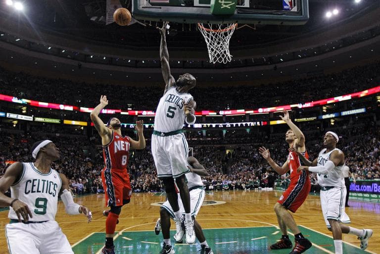 Celtics forward Kevin Garnett (5) blocks a shot by New Jersey Nets point guard Deron Williams (8) during the first half in Boston. (AP)