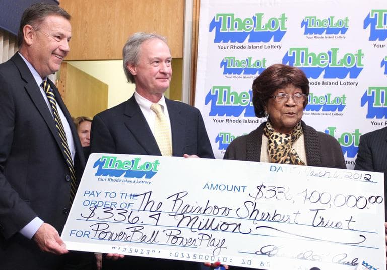 Louise White, right, 81 from Newport, R.I., is presented a check for $336 million by Gerald Aubin, left, director of the state&#039;s lottery, and Gov. Lincoln Chafee, center, at Rhode Island Lottery headquarters in Cranston, R.I., Tuesday. (AP)