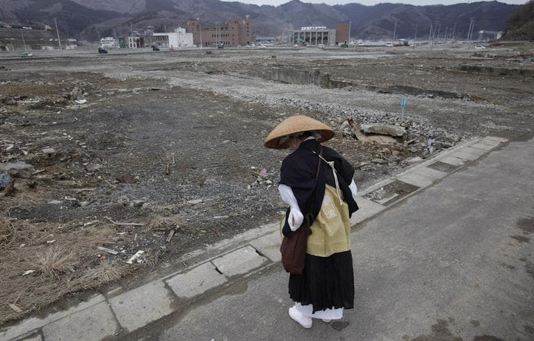A Buddhist monk bows and offers a prayer in a neighborhood destroyed by the March 11 earthquake and tsunami in Onagawa, Miyagi Prefecture, on Friday. (AP) 