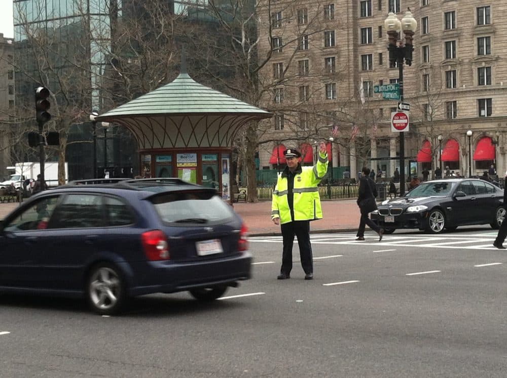 The city has launched an online tool to allow people to report transportation safety concerns for Boston streets. One area that has been reported is the intersection of Boylston and Dartmouth streets in Copley Square.  Pictured: A Boston police officer directs traffic in Copley Square. (Steve Brown/WBUR/FILE)