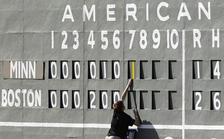 A scorekeeper adds a run to the board at JetBlue Park in Fort Myers, Fla. The scoreboard is very same manual scoreboard that adorned the original “Green Monster” in Boston for nearly three decades, before being put in storage. (AP)