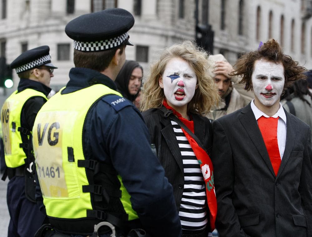 Demonstrators pass British police officers during a protest march against pension cuts in London in November. (AP)