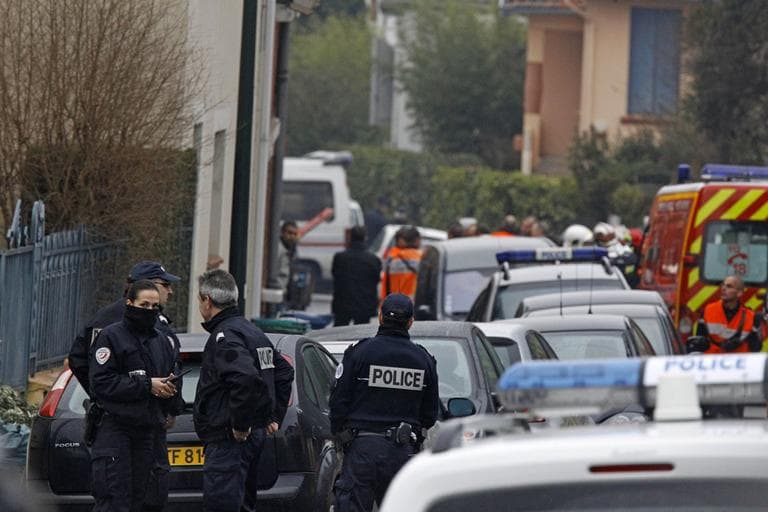 Police officers and firefighters stand next to a building in Toulouse, France, Wednesday, March 21 where a suspect in the shooting at he Ozar Hatorah Jewish school has been spotted. (AP)