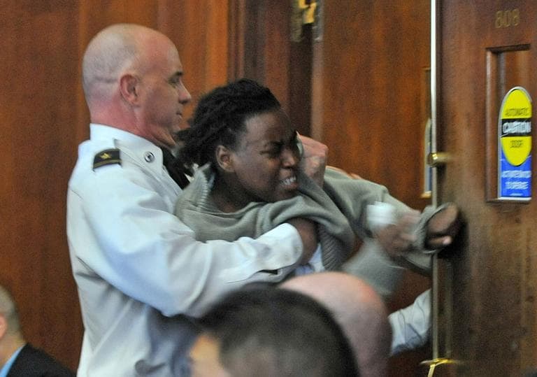 The Boston courtroom erupted following Thursday's verdicts in the trial of two men accused of killing four people on a Mattapan street. Here, a court officer removes a spectator. (AP)