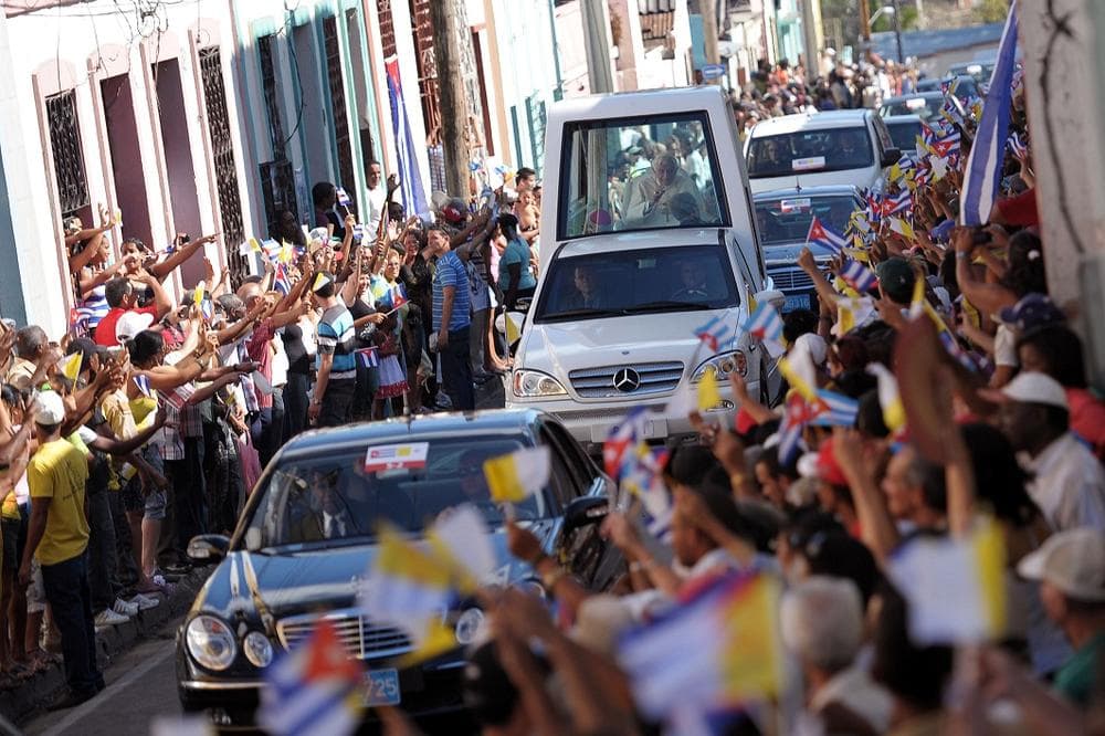 Pope Benedict XVI rides in the popemobile as people gather along the roadside to greet him upon his arrival to Santiago de Cuba, Cuba, on Monday. (AP/Osservatore Romano)
