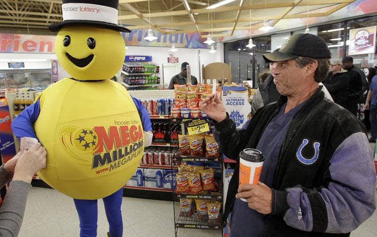 A customer smiles after receiving a free Mega Millions Lottery ticket from the Hoosier Lottery&#039;s Mega Millions mascot at a store in Zionsville, Ind. (AP)