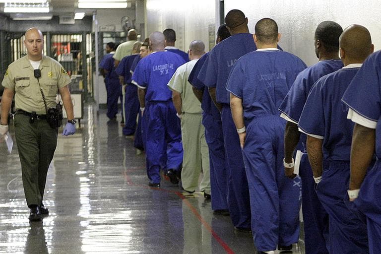 In this Oct. 27, 2011 photo, a deputy passes a line of inmates, as seen during a tour of the Men's Central Jail, run by the Los Angeles County Sheriff's Department, in downtown Los Angeles. (AP)