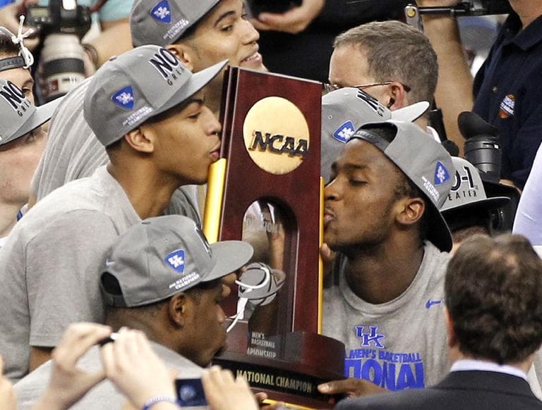 Kentucky forward Anthony Davis, left, and forward Michael Kidd-Gilchrist, right, kiss the trophy after wining the NCAA Final Four tournament college basketball championship game Tuesday. (AP)