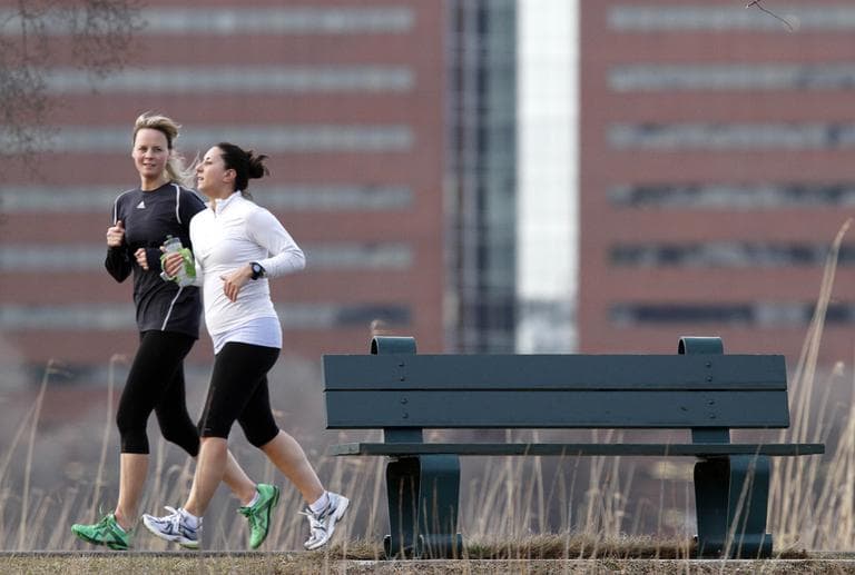 Two women jog on the banks of the Charles River in Boston in March (AP)