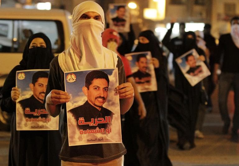 Bahraini anti-government protesters carry images of jailed hunger-striker Abdulhadi al-Khawaja that read &quot;Freedom or martyrdom&quot; during a demonstration Sunday outside the Interior Ministry in Manama, Bahrain. (AP)