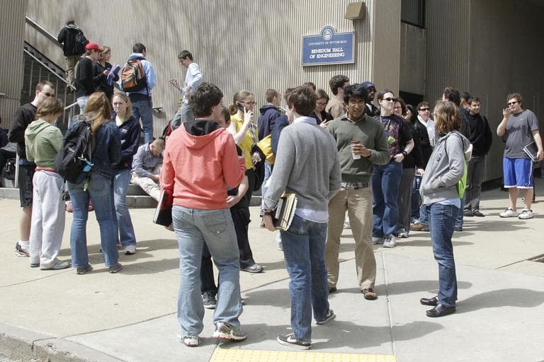 Students wait across the street after being evacuated from buildings on the University of Pittsburgh campus after a bomb threat Monday. (AP)