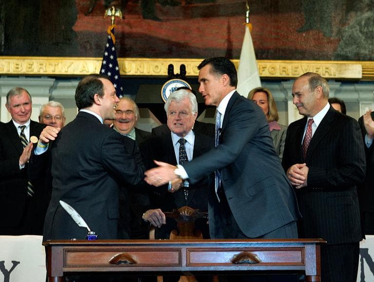 In this April 12, 2006, file photo, then-Gov. Mitt Romney is seen with lawmakers and staffers after signing the state&#039;s universal health coverage law at Faneuil Hall in Boston. (AP File)