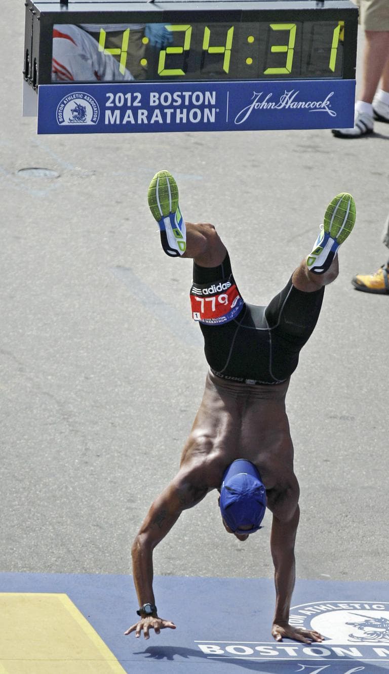 Remus Medley of Baltimore, Md., walks on his hands across the finish line of the 116th Boston Marathon in Boston. (AP)