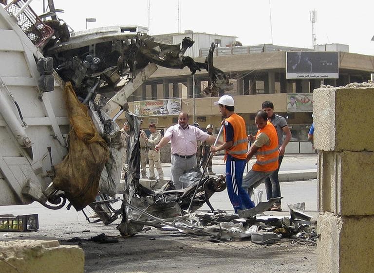Baghdad municipality workers clean up after a car bomb attack in Palestine Street, Baghdad Iraq, Thursday. A wave of morning bombings across several cities on Thursday. (AP)