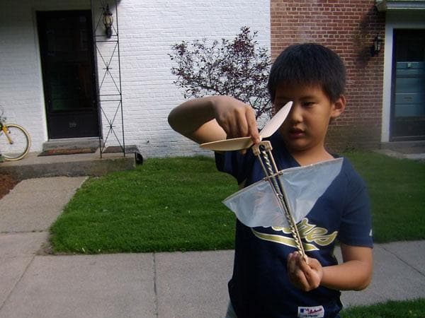 One of Ms. Nic's pupils with a homemade flying toy. (Photo Courtesy)