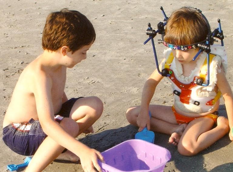 Riley wearing the halo while playing on the beach with her brother Cole (Courtesy of Kristen Davis)
