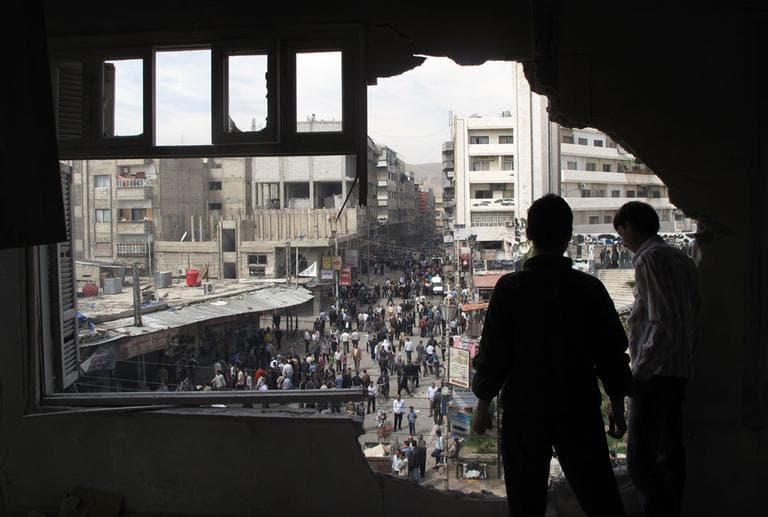 Syrian youth stand in a building damaged by tank shells in a neighborhood of Damascus, Syria, after a raid by Syrian troops killed several rebels and civilians Thursday, April 5, 2012. (AP)