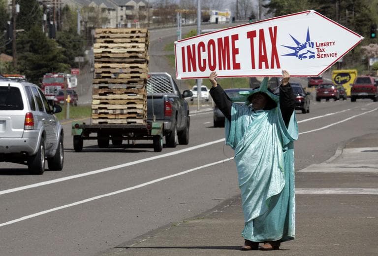 Dressed as the Statue of Liberty, Sonia Joaquin holds a sign to remind passing motorists that Thursday is the deadline for taxes in Tigard, Ore. on Thursday, April 15, 2010. (AP)