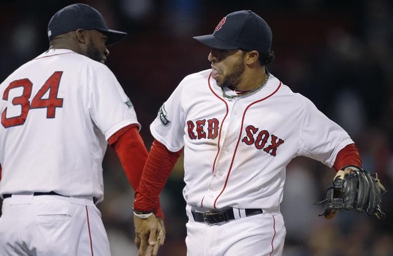 Red Sox shortstop Mike Aviles, right, low-fives teammate David Ortiz after beating the Oakland Athletics, 11-6, in a baseball game at Fenway Park. (AP)
