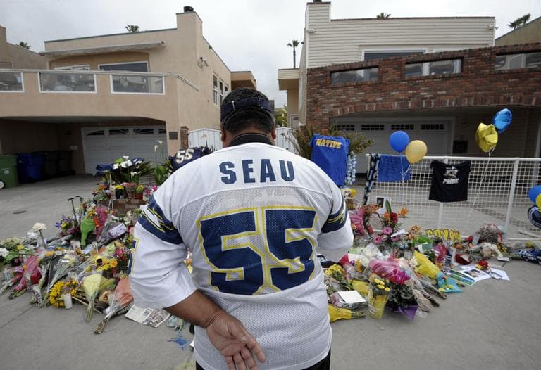 San Diego Chargers fan Jerry Lopez looks over a memorial set-up in the driveway of the house of former NFL star Junior Seau Thursday, May 3 in Oceanside, Calif. (AP)