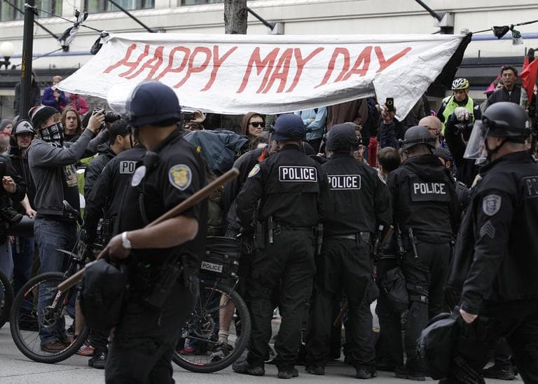 Police push back protesters near a banner that reads &quot;Happy May Day,&quot; Tuesday, May 1, 2012, during May Day protests in downtown Seattle. Hundreds of activists across the U.S. joined the worldwide May Day protests on Tuesday, with Occupy Wall Street members in several cities leading demonstrations against major financial institutions. (AP)